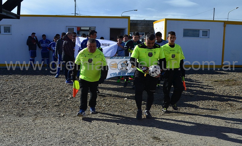 Los árbitros encabezan la salida de los equipos a campo de juego.