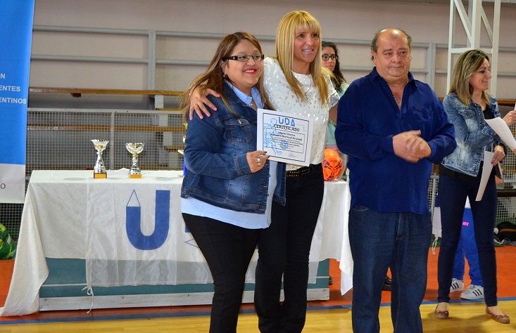 Fanny Abregú (ctro.) entrega un reconocimiento a Valeria Andrade y Oscar Villafañe de la Cooperativa Eléctrica. 